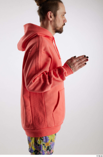 Nigel 1 arm dressed flexing salmon hoodie sweatshirt side view…